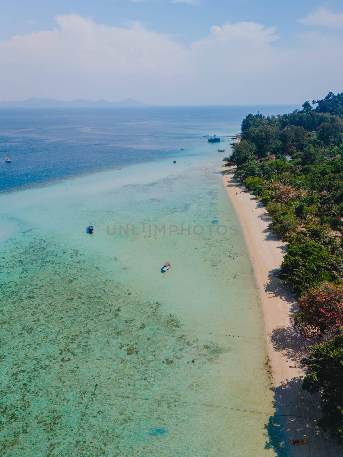 aerial view at Koh Kradan a tropical island with palm trees soft white sand, and a turqouse colored ocean in Koh Kradan Trang Thailand