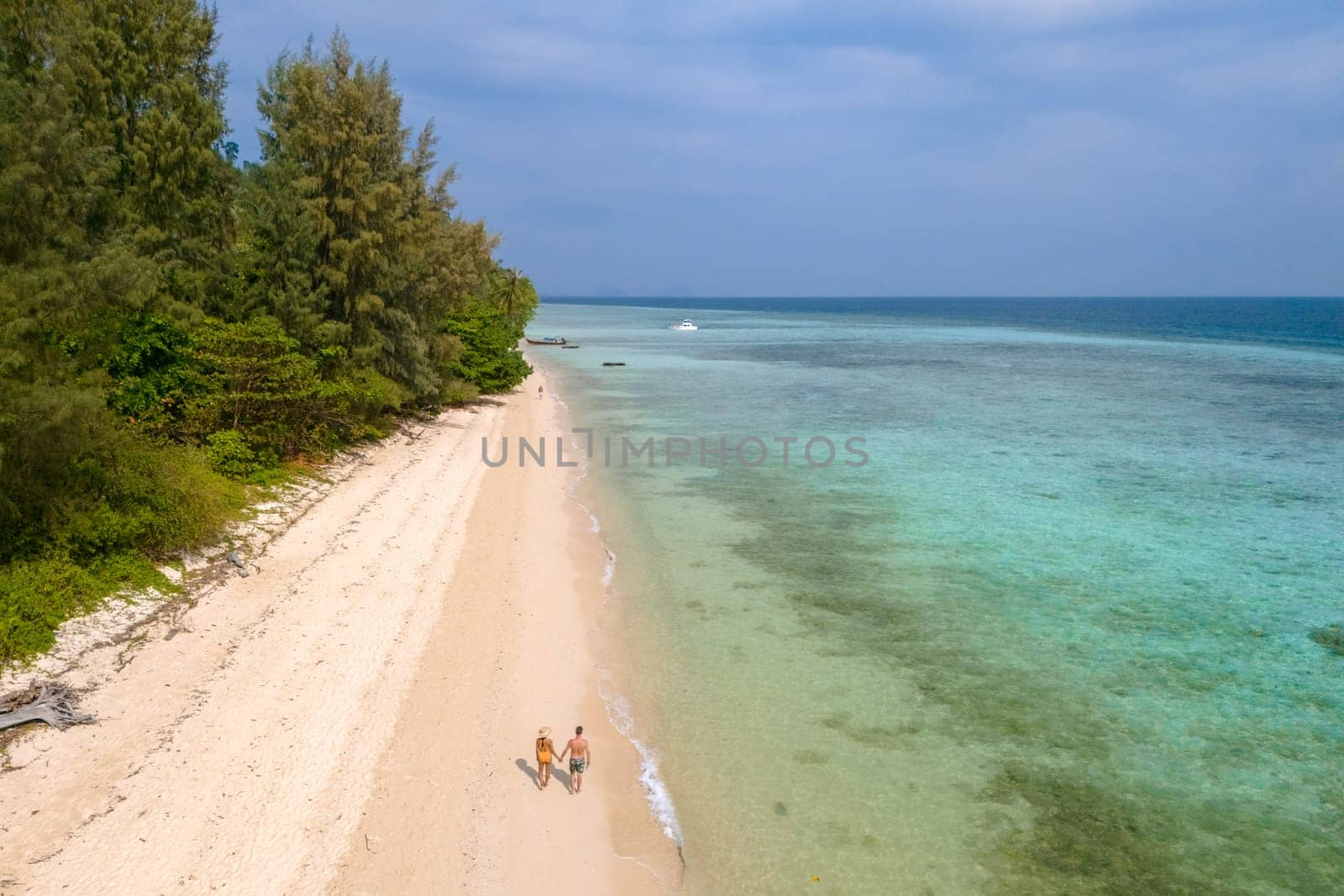 Drone aerial view at Koh Ngai island with palm trees and soft white sand, and a turqouse colored ocean in Koh Ngai Trang Thailand