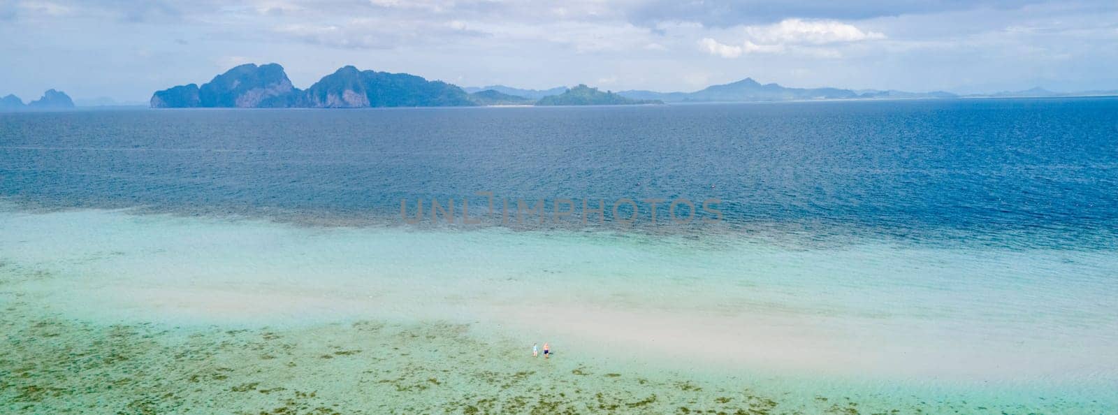 aerial view at Koh Kradan a tropical island with palm trees soft white sand, and a turqouse colored ocean in Koh Kradan Trang Thailand at sunset