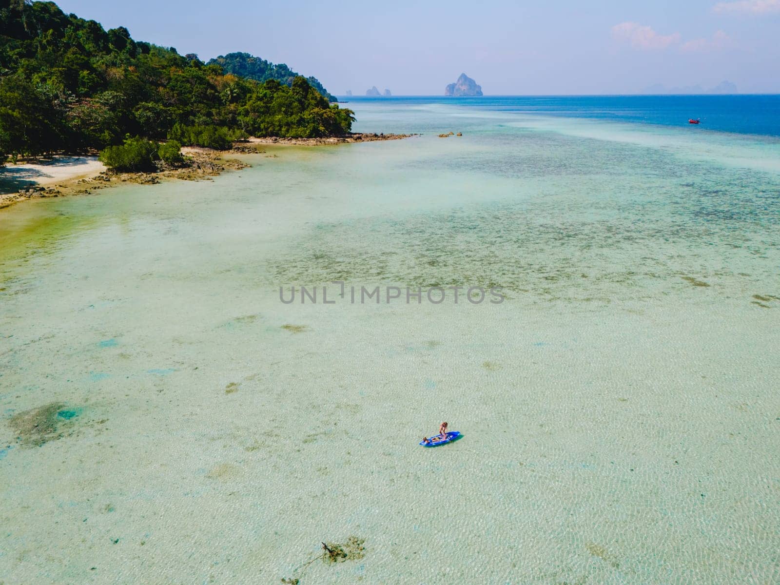 woman at peddle board sup at Koh Kradan a tropical island in Thailand, Top down view picture of a woman paddling on the sup board.