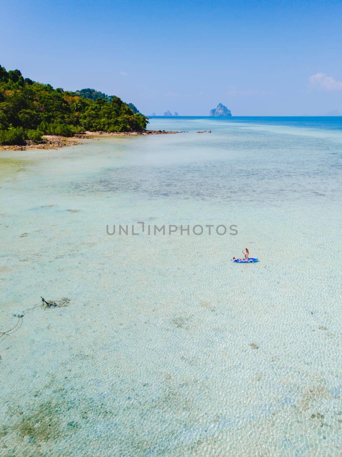 woman at peddle board sup at Koh Kradan a tropical island in Thailand, Top down view picture of a woman paddling on the sup board.