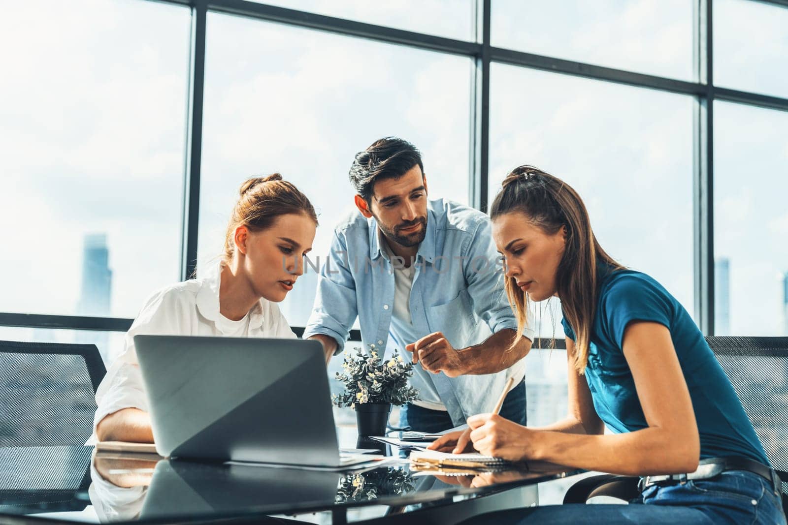 Group of diverse profession business people pointing at laptop displayed idea. Portrait of business team show marketing strategy present by laptop with statistic document scatter on table. Tracery.