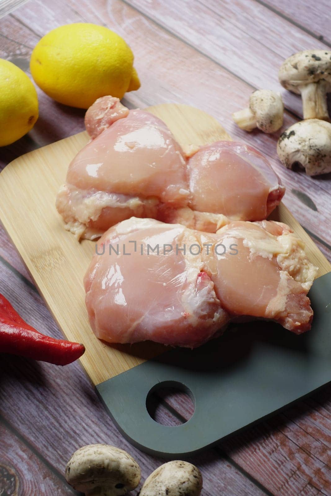 raw breast chicken meat on a chopping board by towfiq007