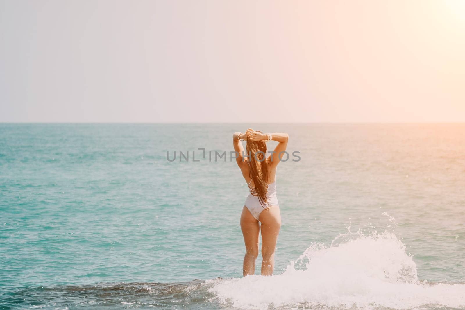 Woman sea yoga. Back view of free calm happy satisfied woman with long hair standing on top rock with yoga position against of sky by the sea. Healthy lifestyle outdoors in nature, fitness concept.