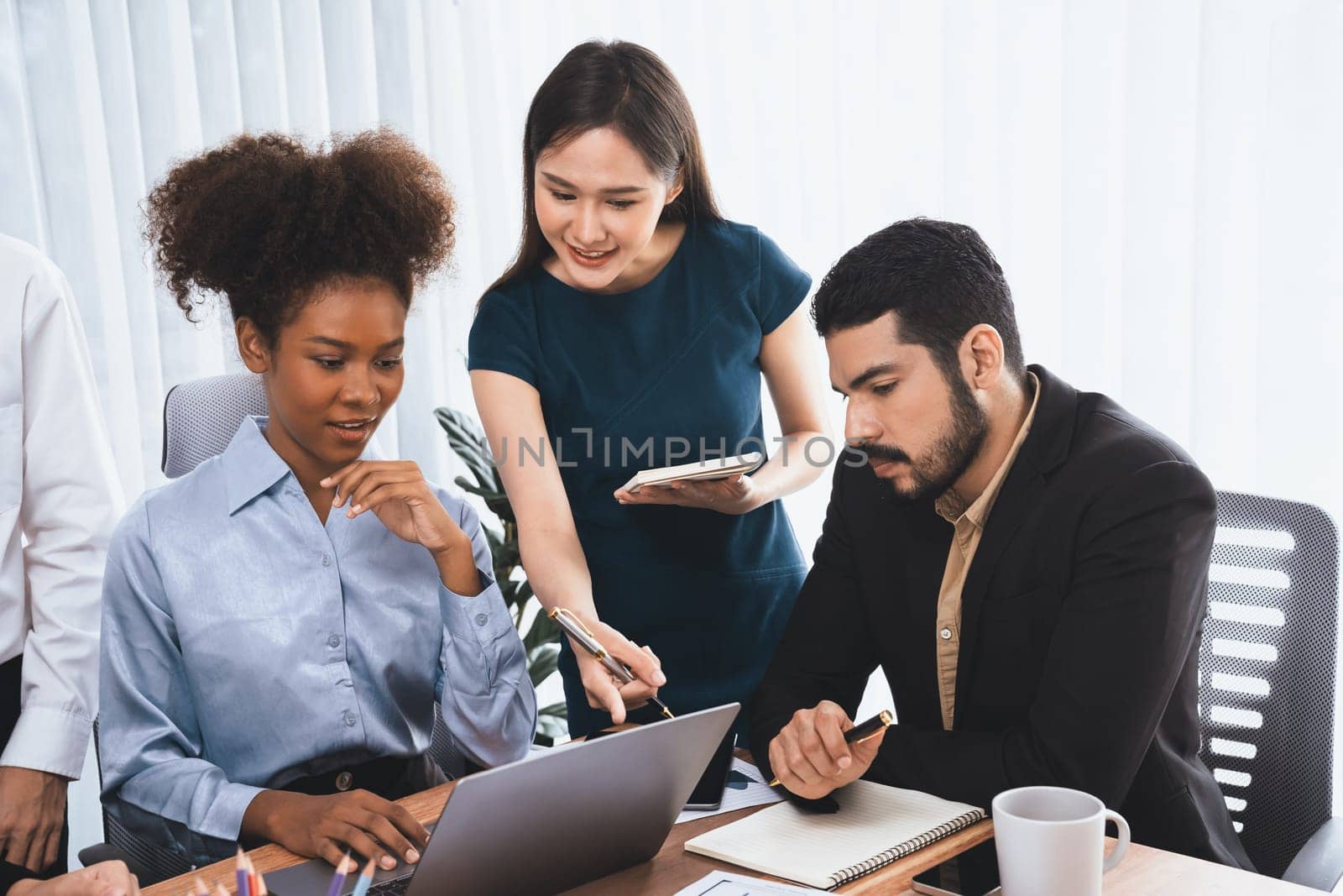 Happy diverse business people work together, discussing in corporate office. Professional and diversity teamwork discuss business plan on desk with laptop. Modern multicultural office worker. Concord