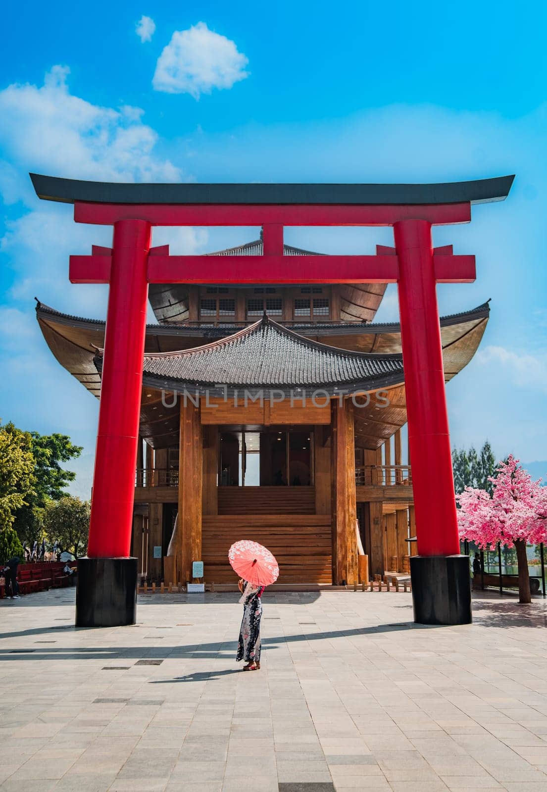 Asian girl in kimono and umbrella in Japanese theme park Hinoki Land in Chai Prakan District, Chiang Mai