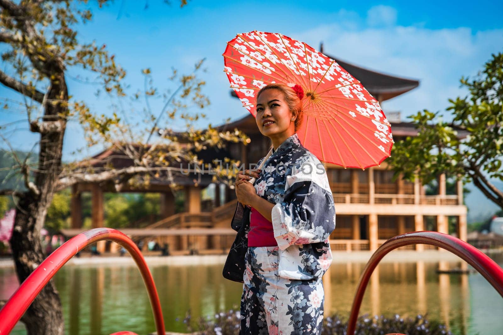 Asian girl in kimono and umbrella in Japanese theme park Hinoki Land in Chai Prakan District, Chiang Mai