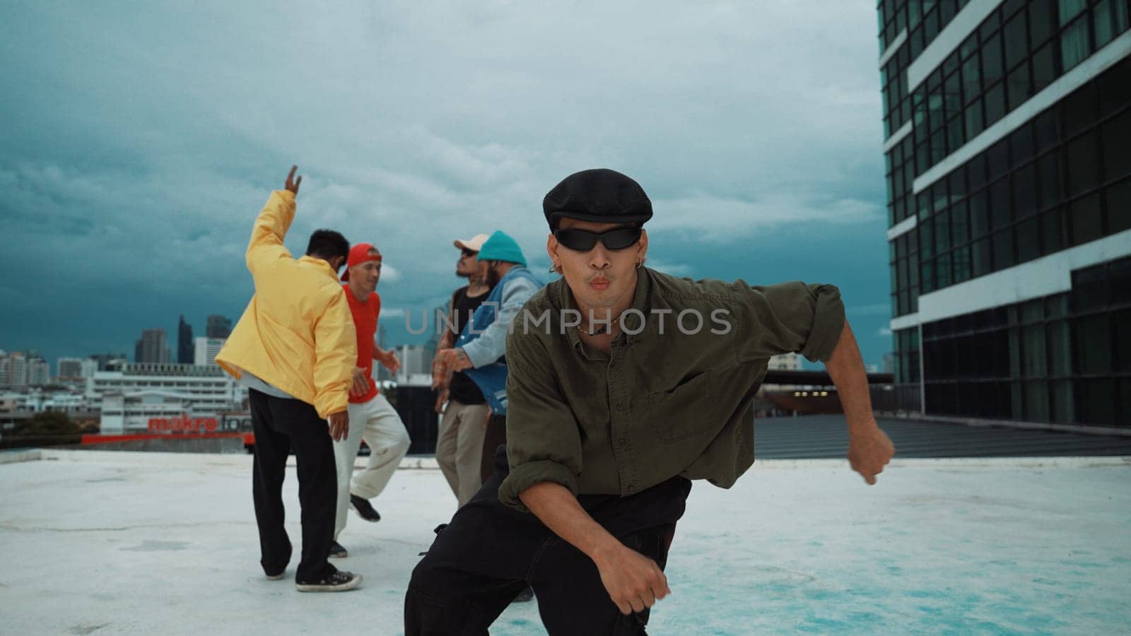 Professional asian dancer practice B boy dance while multicultural friends dancing at roof top. Young modern dancing group doing hip hop movement. Style,fashion,action. Outdoor sport 2024. Endeavor.