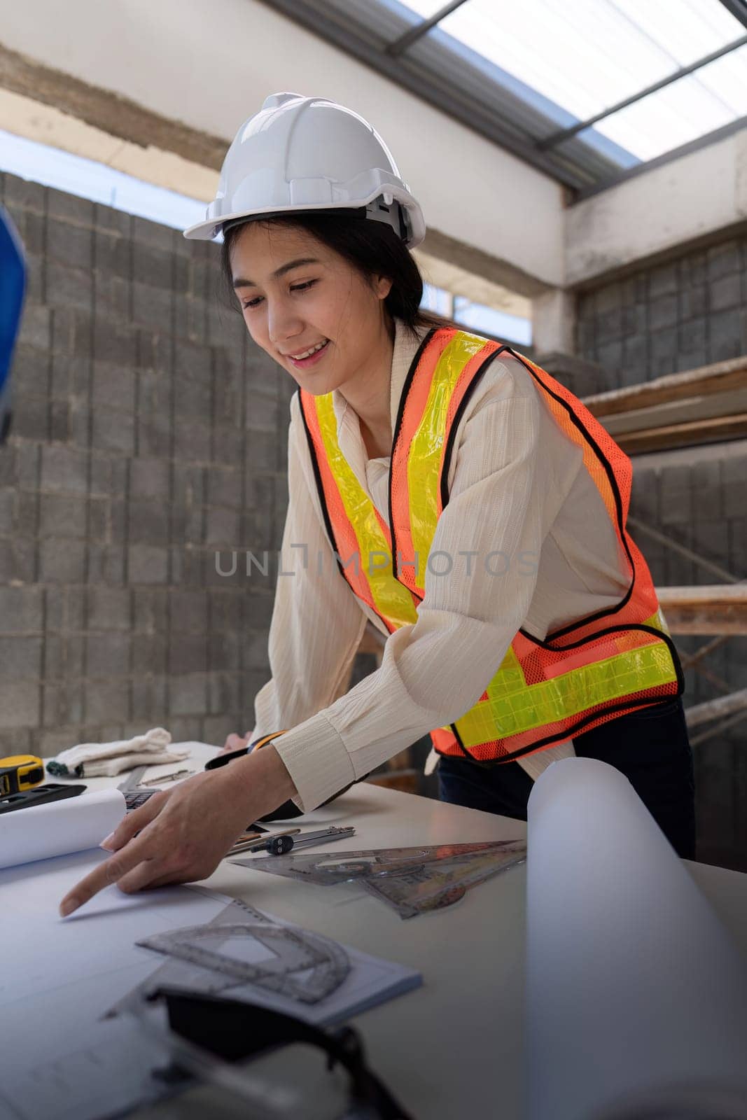 Female construction engineer. Architect with a blueprint at a construction site.
