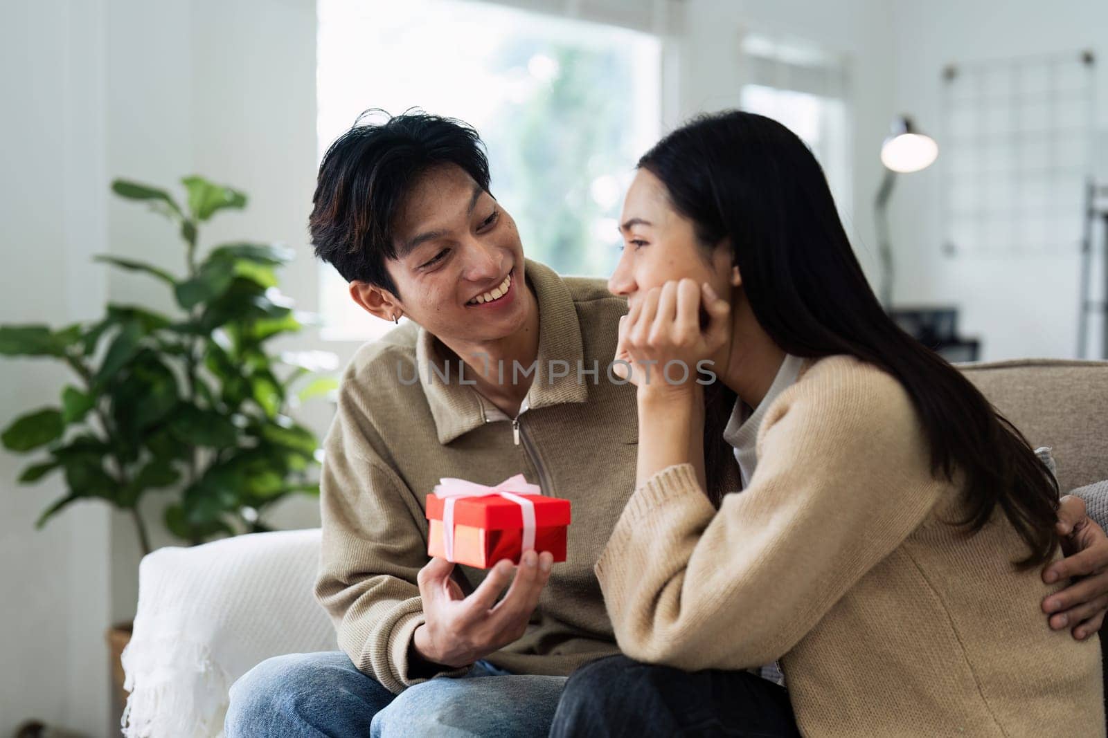 Young couple Hug and giving present on Valentine's Day. Romantic day together. Valentine's Day concept.