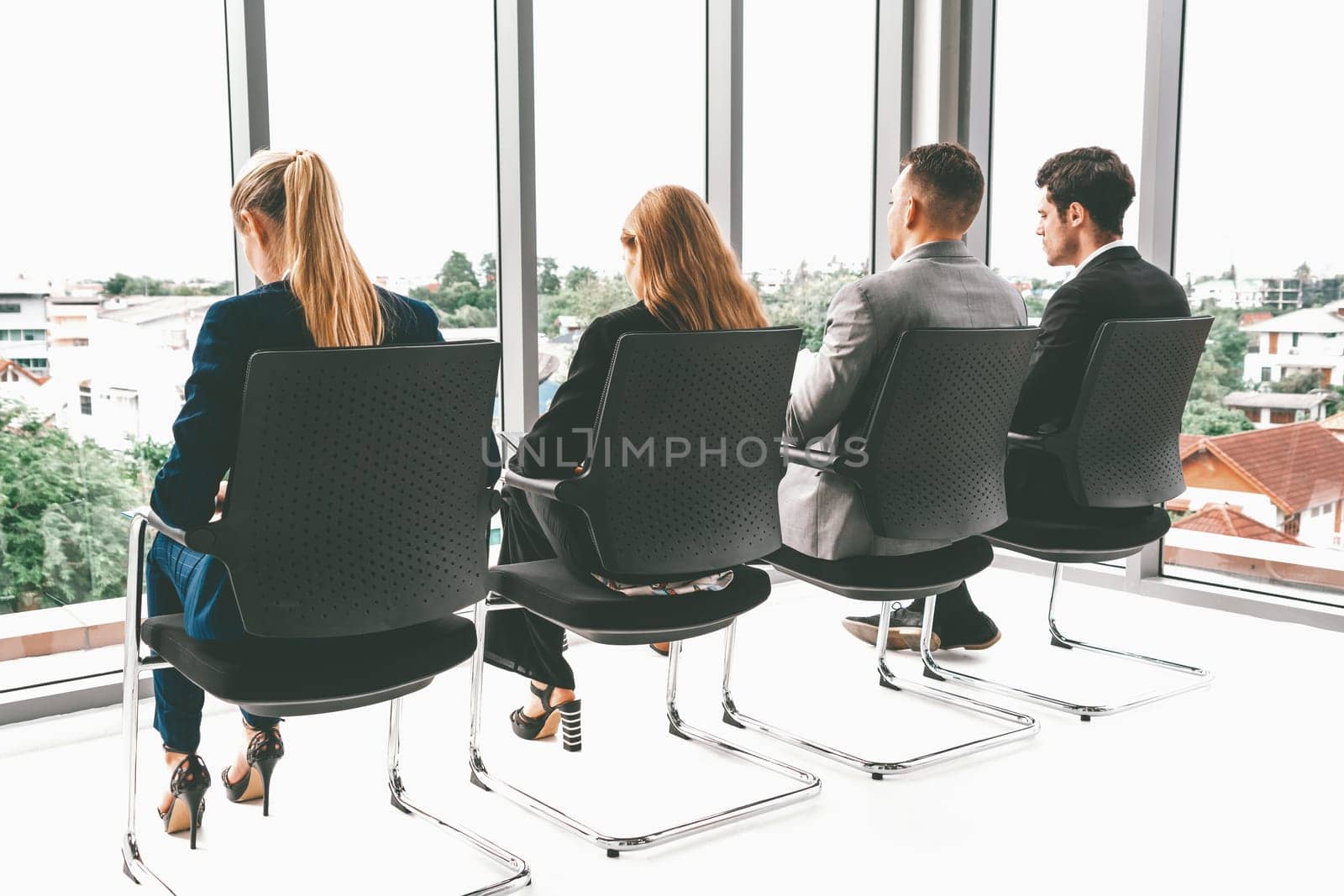 Businesswomen and businessmen waiting on chairs in office for job interview. Corporate business and human resources concept. uds