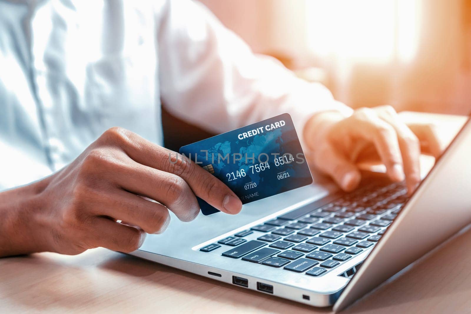 Young man use credit card for shopping payment online on laptop computer application or website. E-commerce and online shopping concept. uds