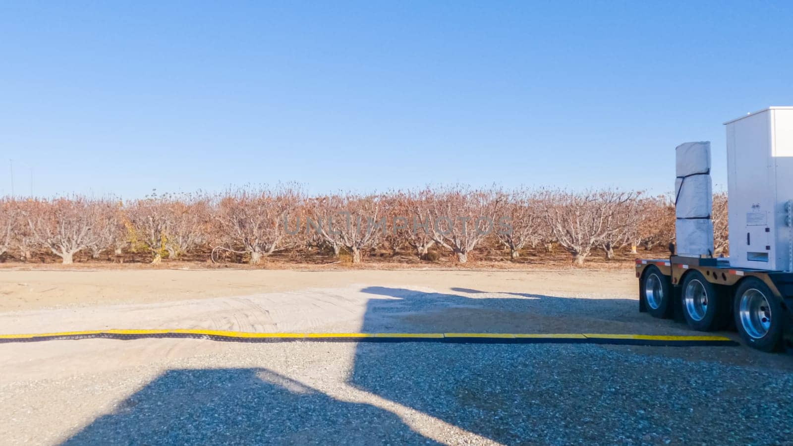 Santa Maria, California, USA-December 6, 2022-Parked trailer, laden with equipment, stands ready for the installation of a new Tesla Supercharger. This image captures a snapshot of innovation as preparations are made to expand electric vehicle charging infrastructure.