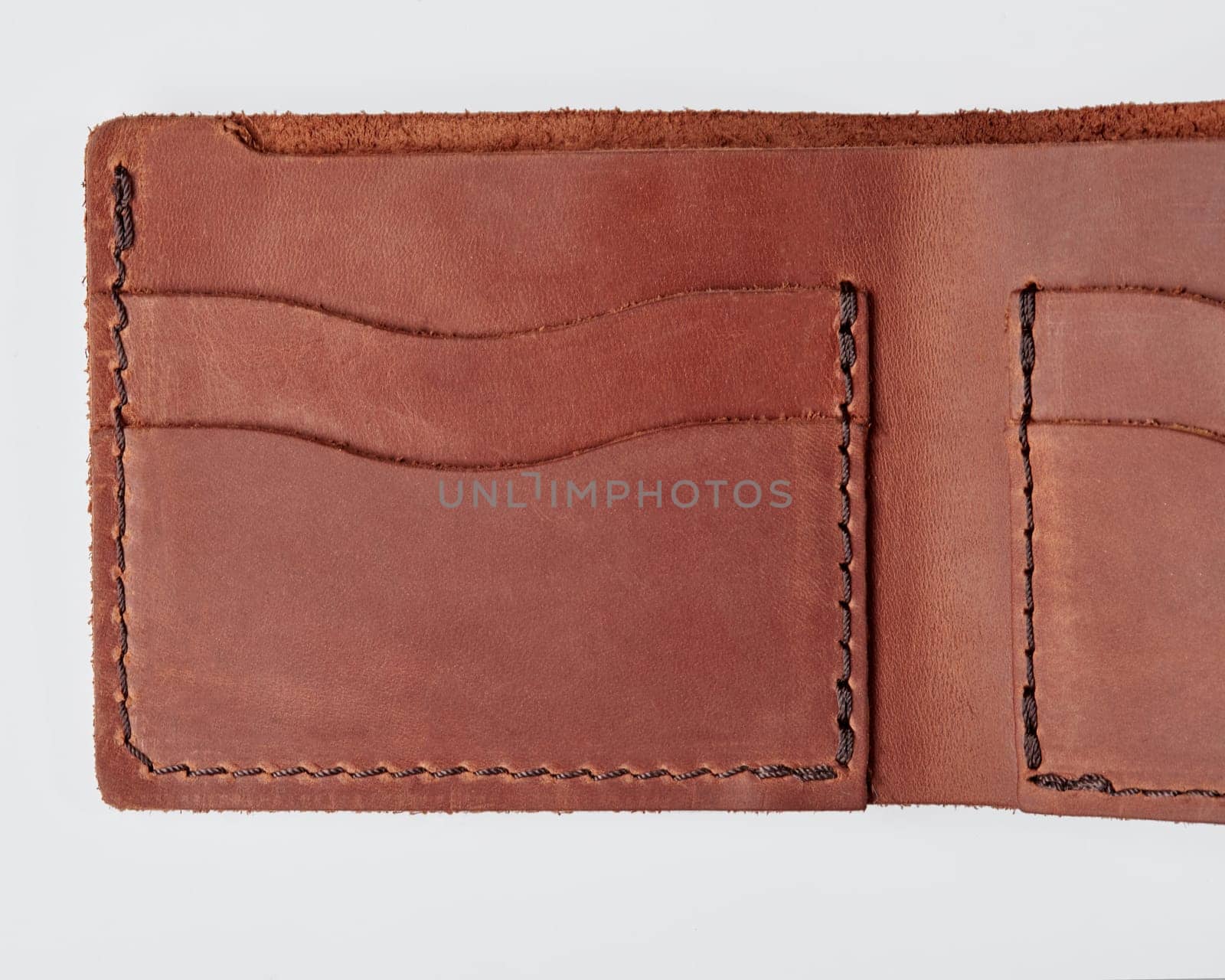 Closeup of open stylish wallet of genuine brown leather with decorative stitching perfect for organizing banknotes, credit cards and drivers license isolated on white background