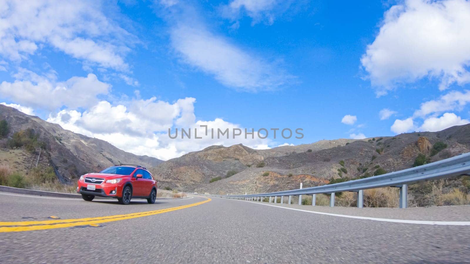 Santa Maria, California, USA-December 6, 2022-Vehicle is cruising along the Cuyama Highway under the bright sun. The surrounding landscape is illuminated by the radiant sunshine, creating a picturesque and inviting scene as the car travels through this captivating area.