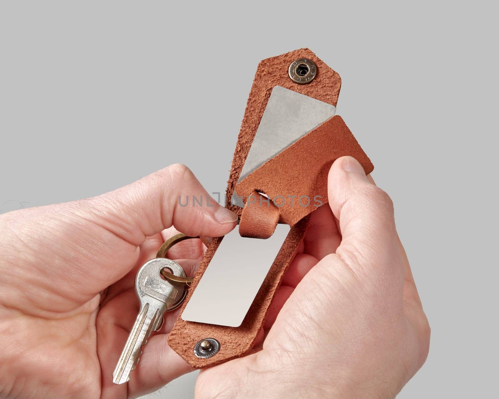 Custom brown leather key holder with printed photo in male hands by nazarovsergey