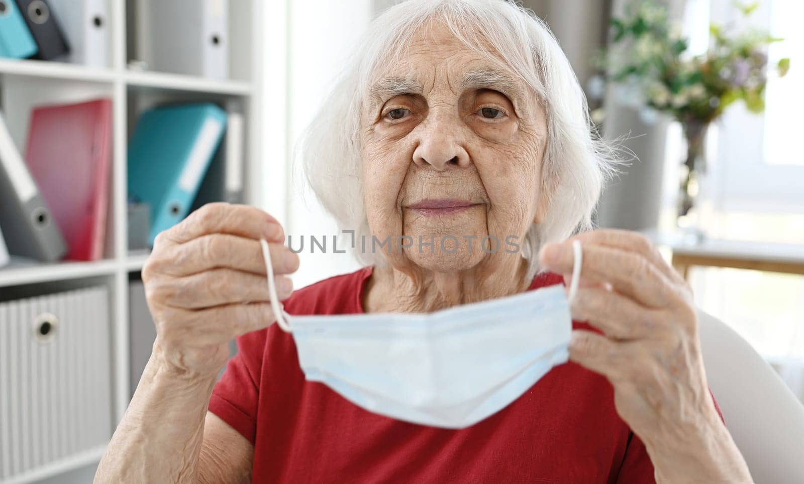 Elderly Woman Puts On Protective Medical Mask by GekaSkr