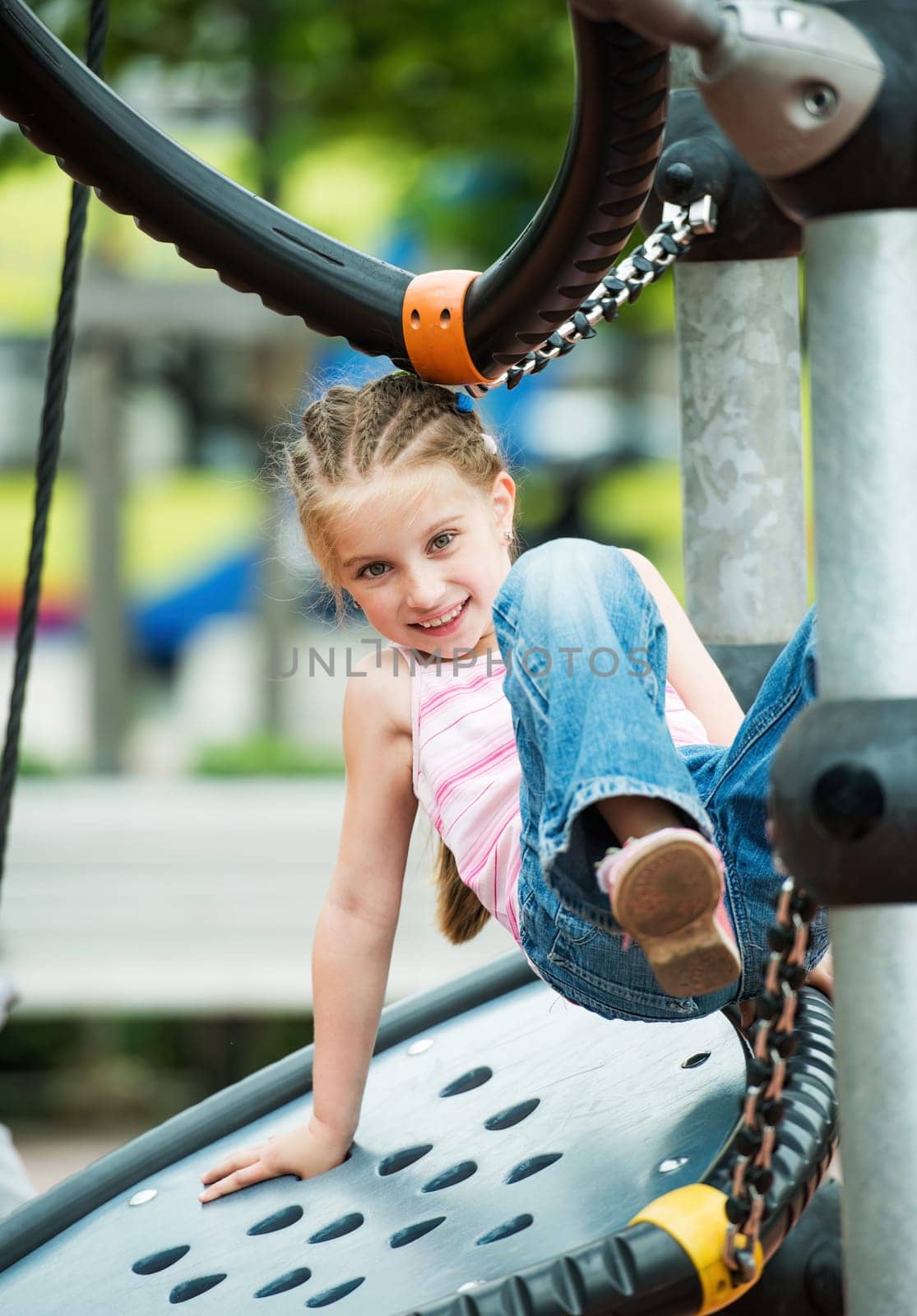 Happy little girl playing at the playground outdoor