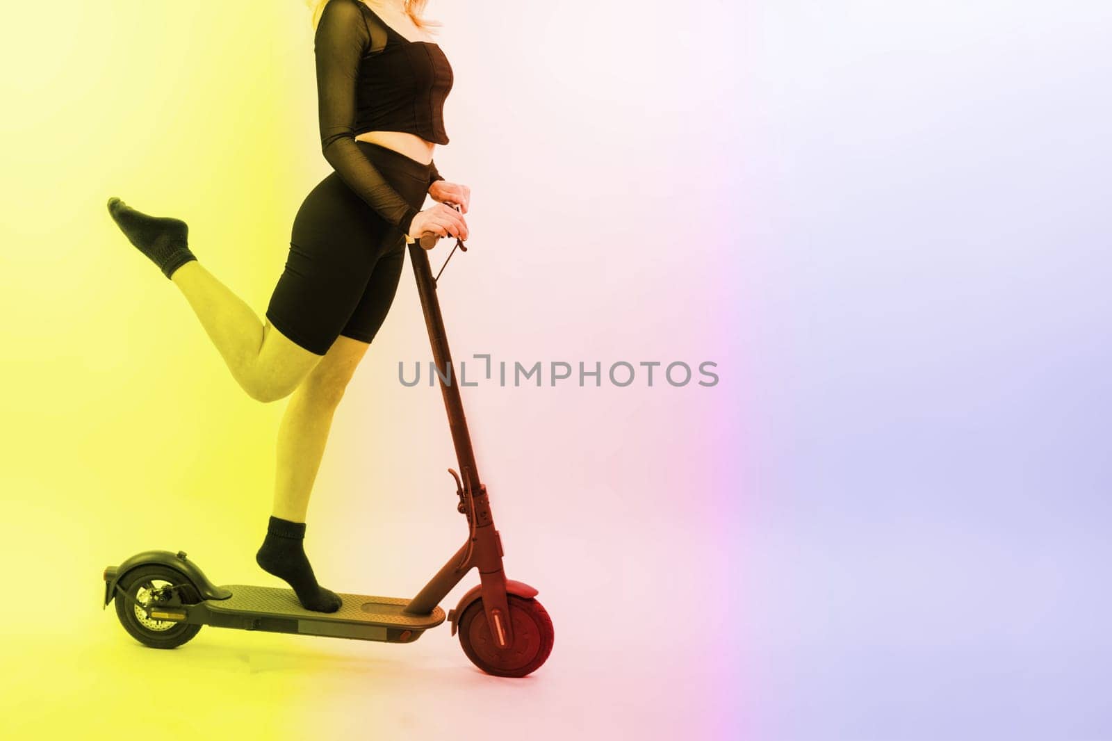 A blonde woman on a red background sitting on electro scooter and resting, copy space