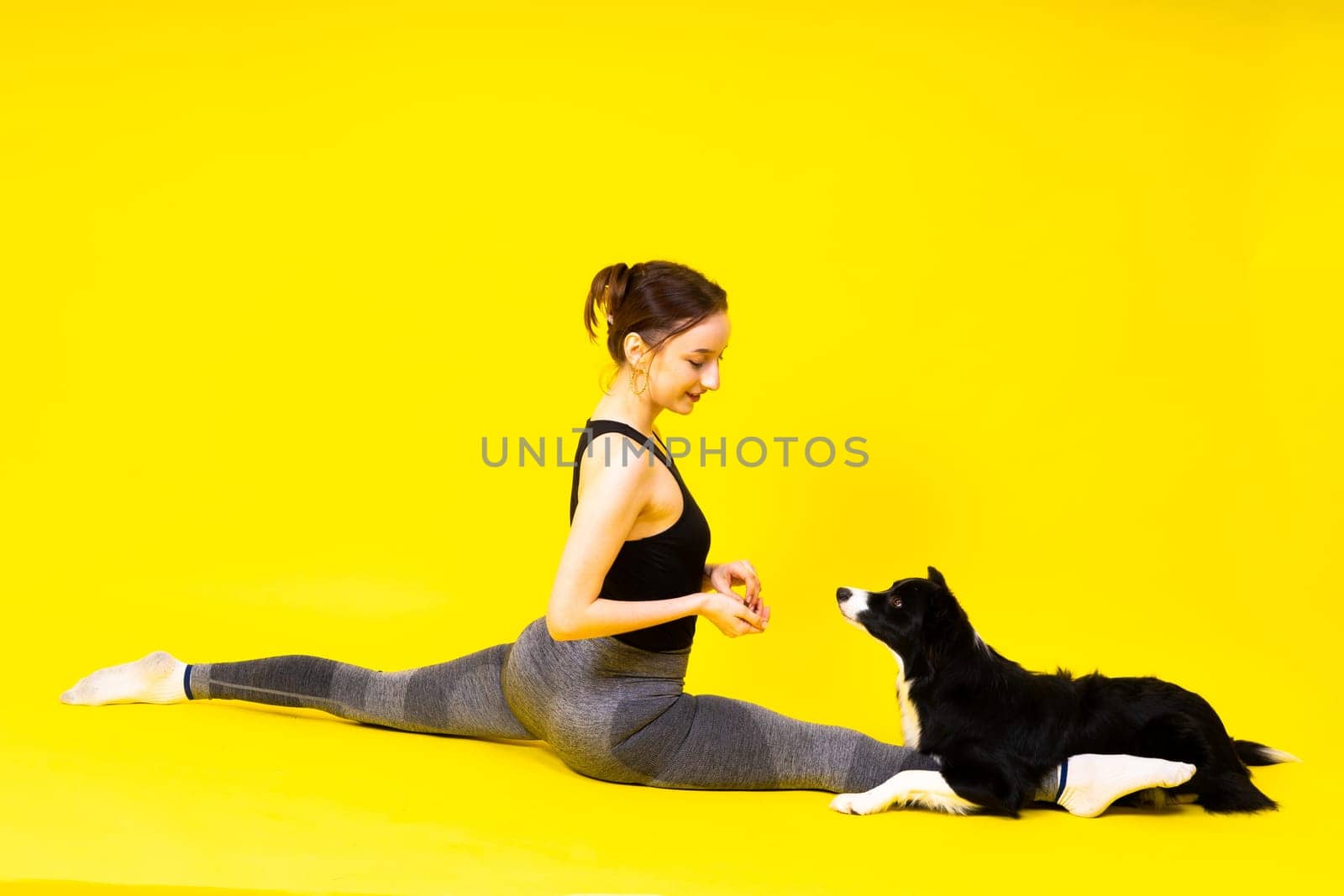 Beautiful sport female with border collie in a studio