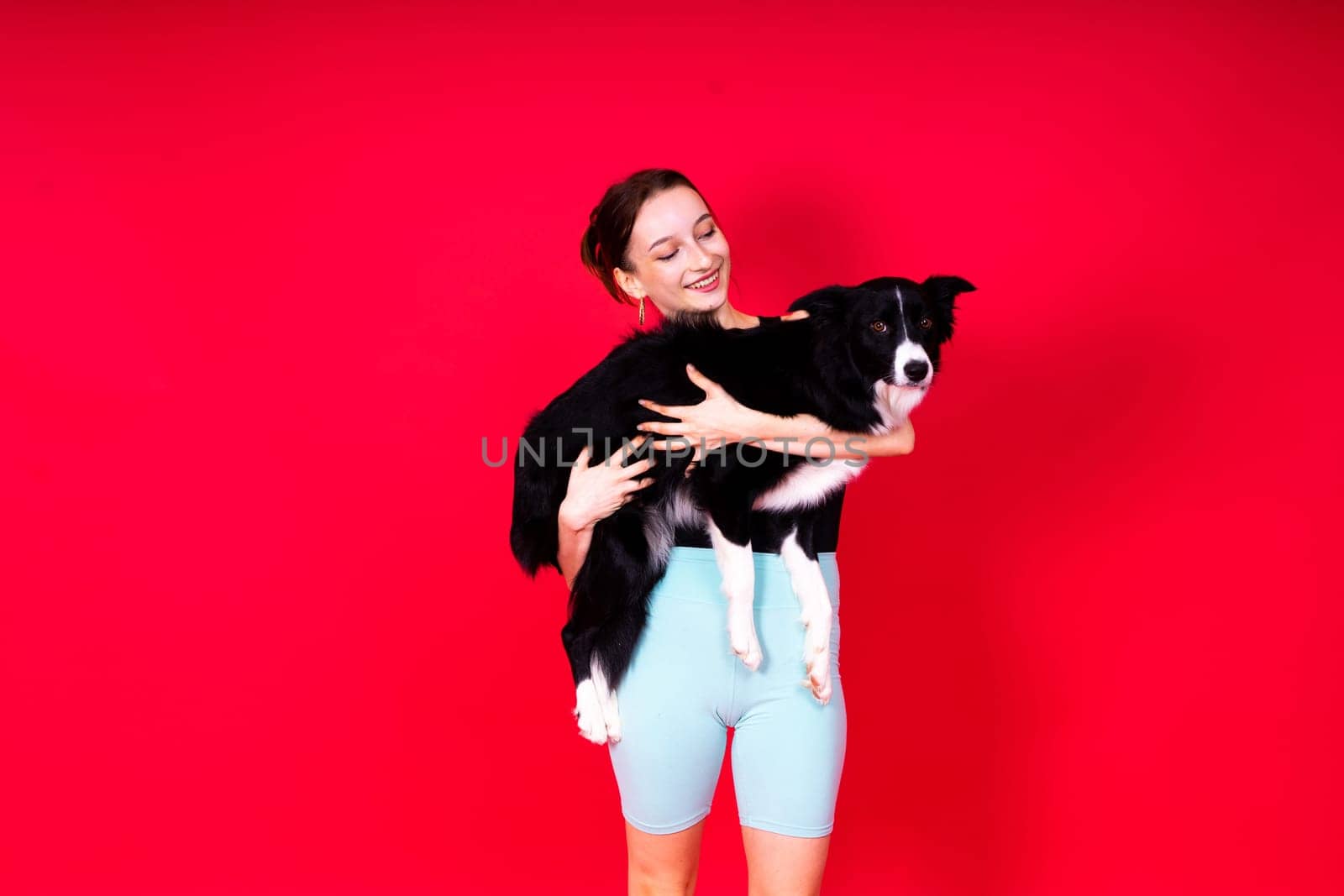 Beautiful sport female with border collie in a studio