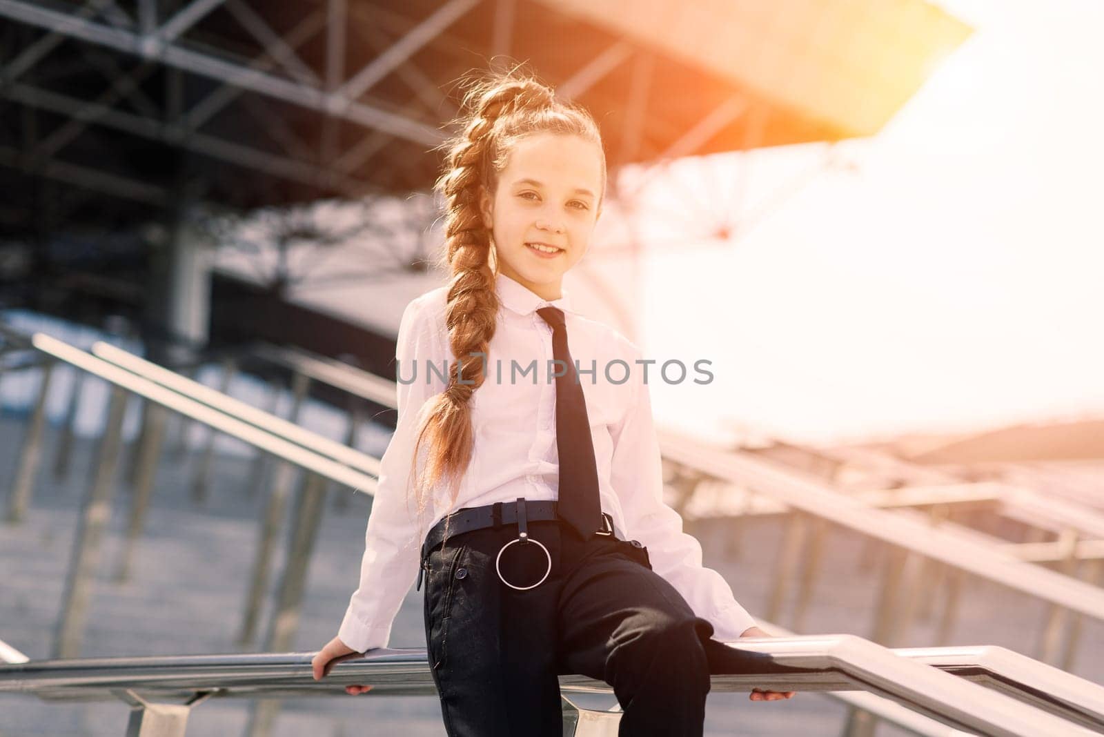 Young schoolgirl in white classical blouse posing in the city
