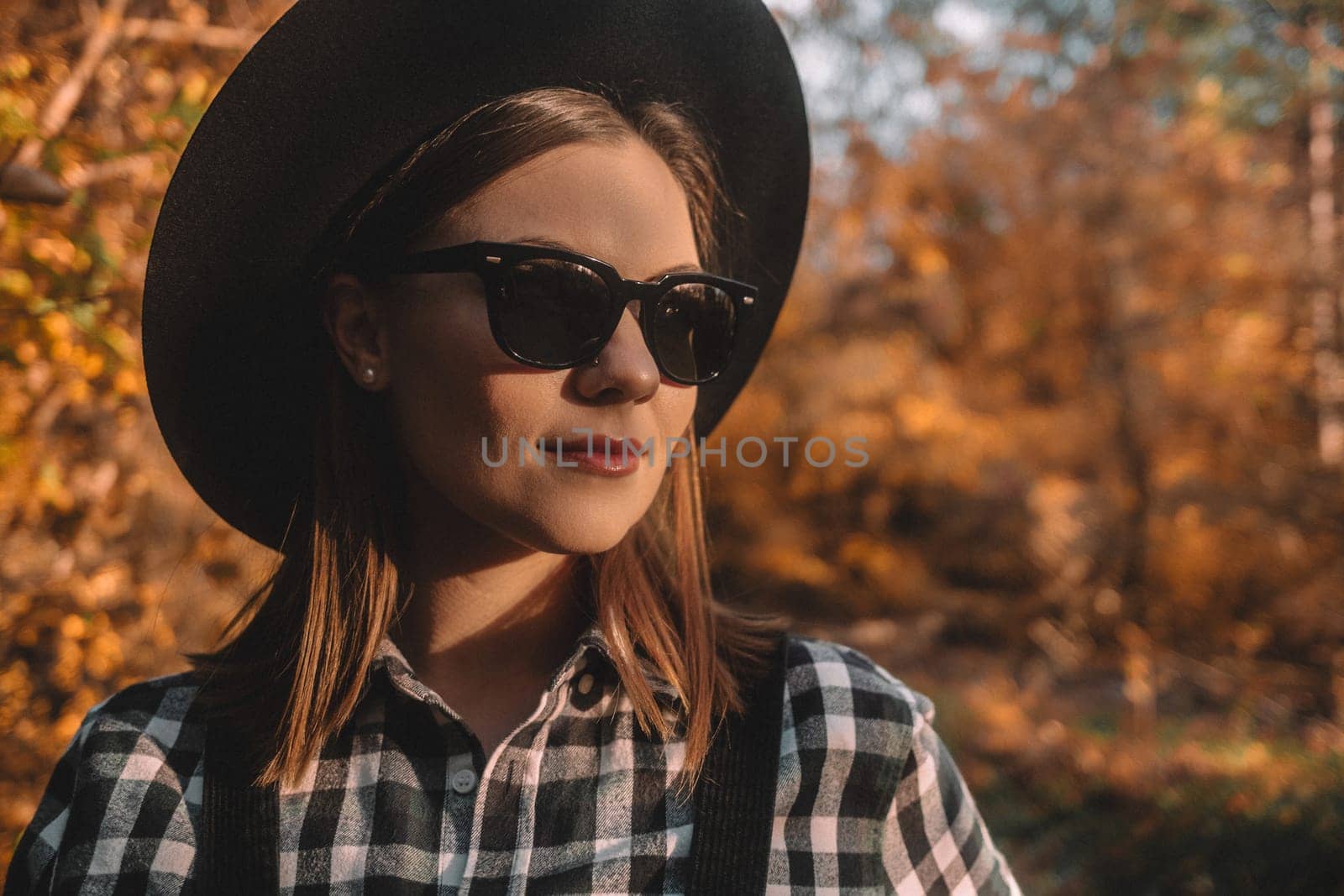 Hipster woman portrait, autumn park, beautiful golden nature. Lifestyle, hat, black sunglasses. High quality photo
