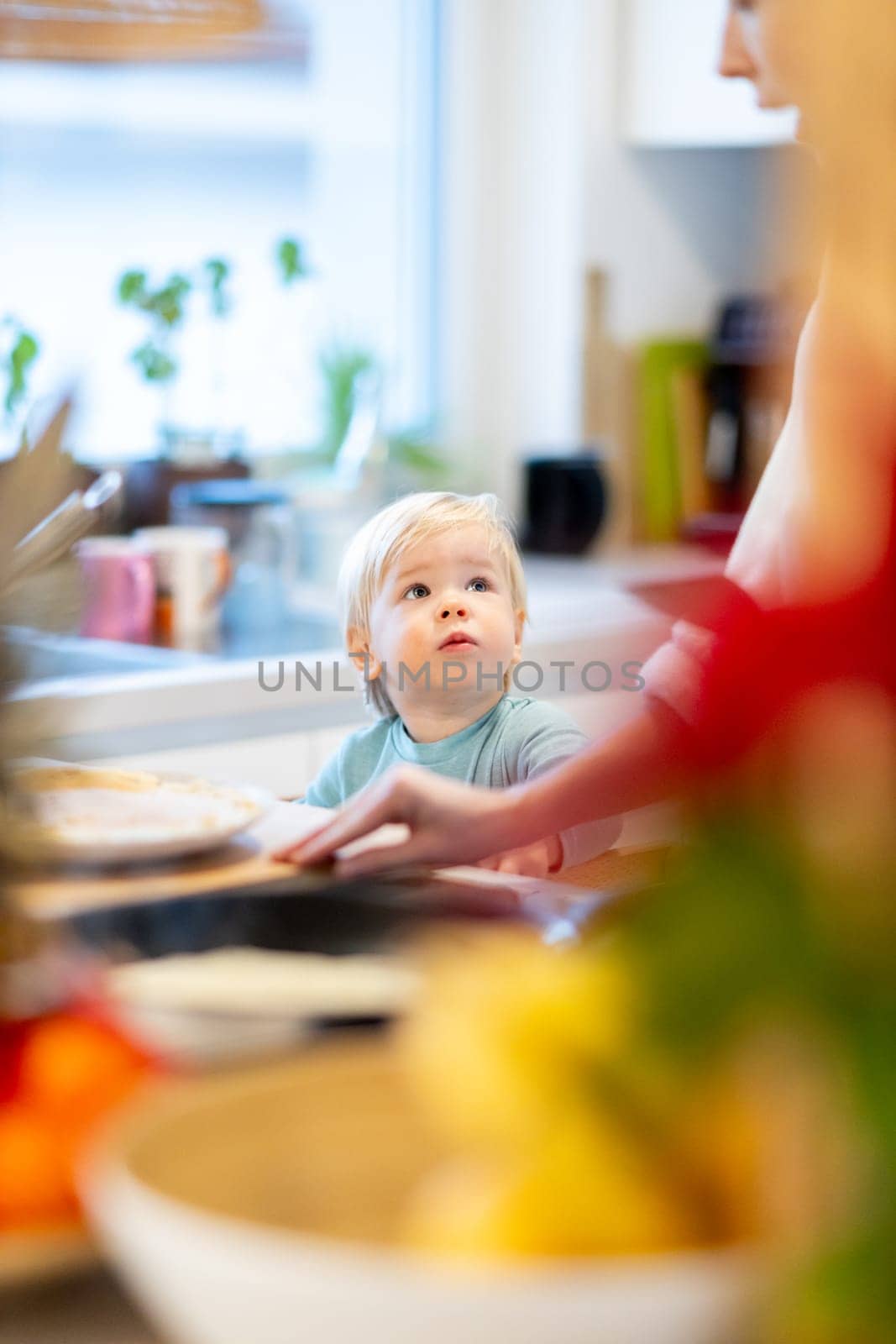 Mother and little toddler baby boy making pancakes for breakfast together in domestic kitchen. Family, lifestyle, domestic life, food, healthy eating and people concept. by kasto
