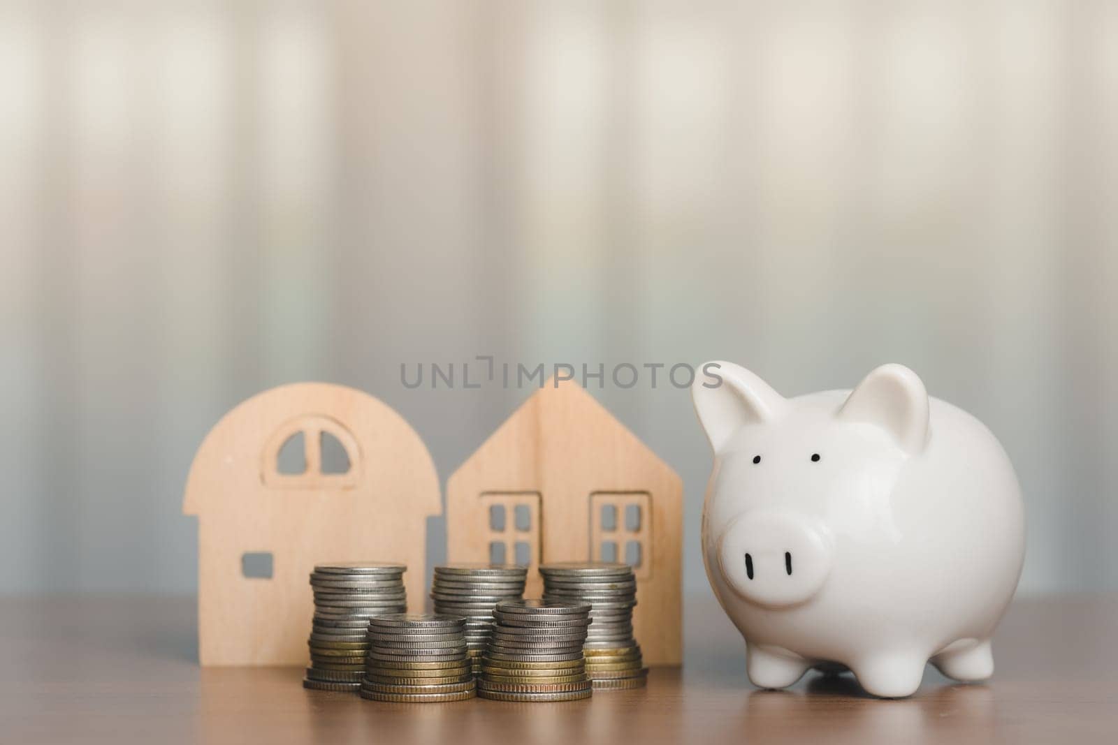 Piggy bank with coins and the wooden house model for business, finance, saving money and property investment concept by iamnoonmai