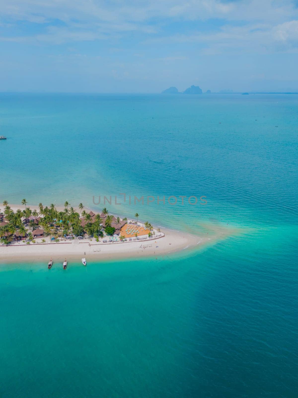Top view at Koh Muk a tropical island with palm trees and soft white sand, and a turqouse colored ocean, sandbar in the ocean in Koh Mook Trang Thailand