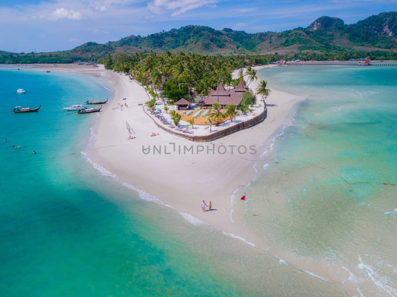 Drone aerial view at Koh Muk a tropical island with palm trees and soft white sand, and a turqouse colored ocean in Koh Mook Trang Thailand