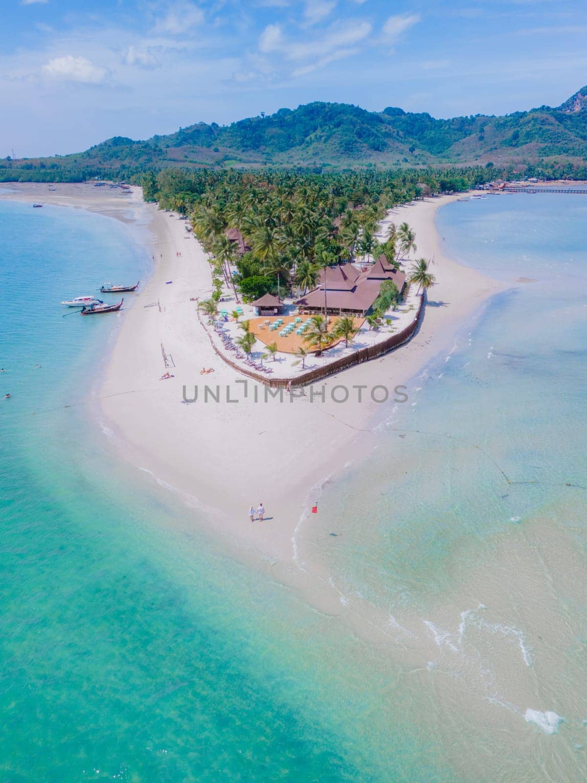 Drone aerial view at Koh Muk a tropical island with palm trees and soft white sand, and a turqouse colored ocean in Koh Mook Trang Thailand