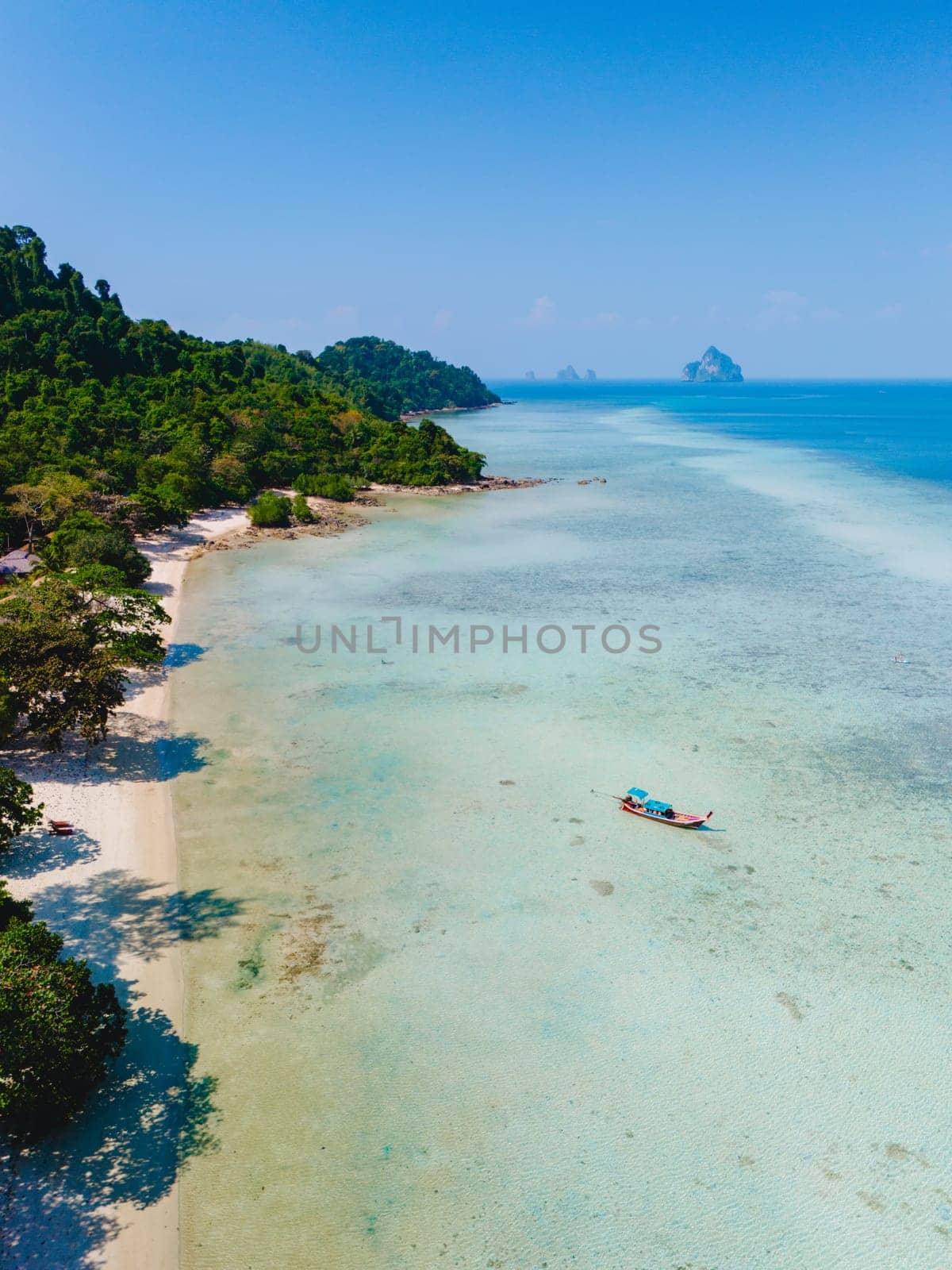 Drone aerial view at Koh Kradan a tropical island with palm trees soft white sand, and a turqouse colored ocean in Koh Kradan Trang Thailand