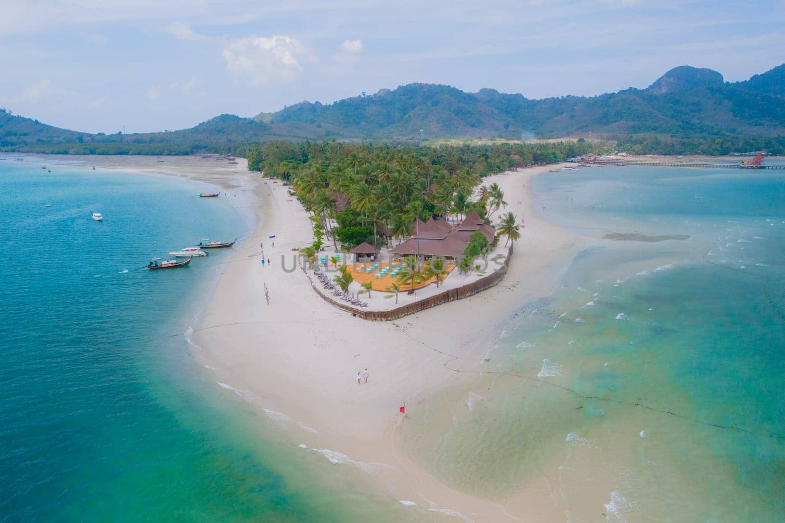 Drone aerial view at Koh Muk a tropical island with palm trees and soft white sand, and a turqouse colored ocean in Koh Mook Trang Thailand