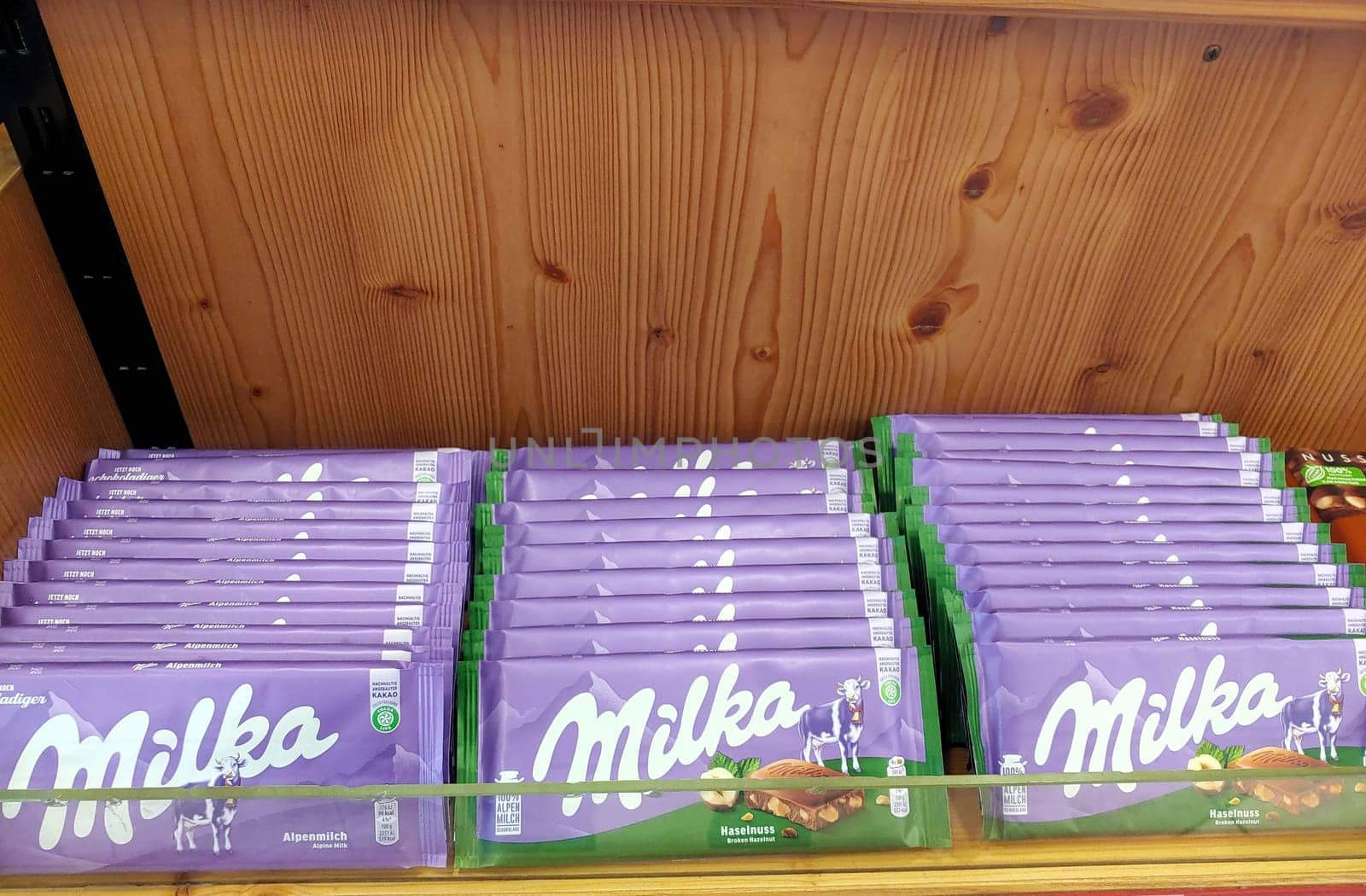 An array of Milka chocolate bars neatly organized on the shelves of a supermarket, showcasing the popular confectionery brand.