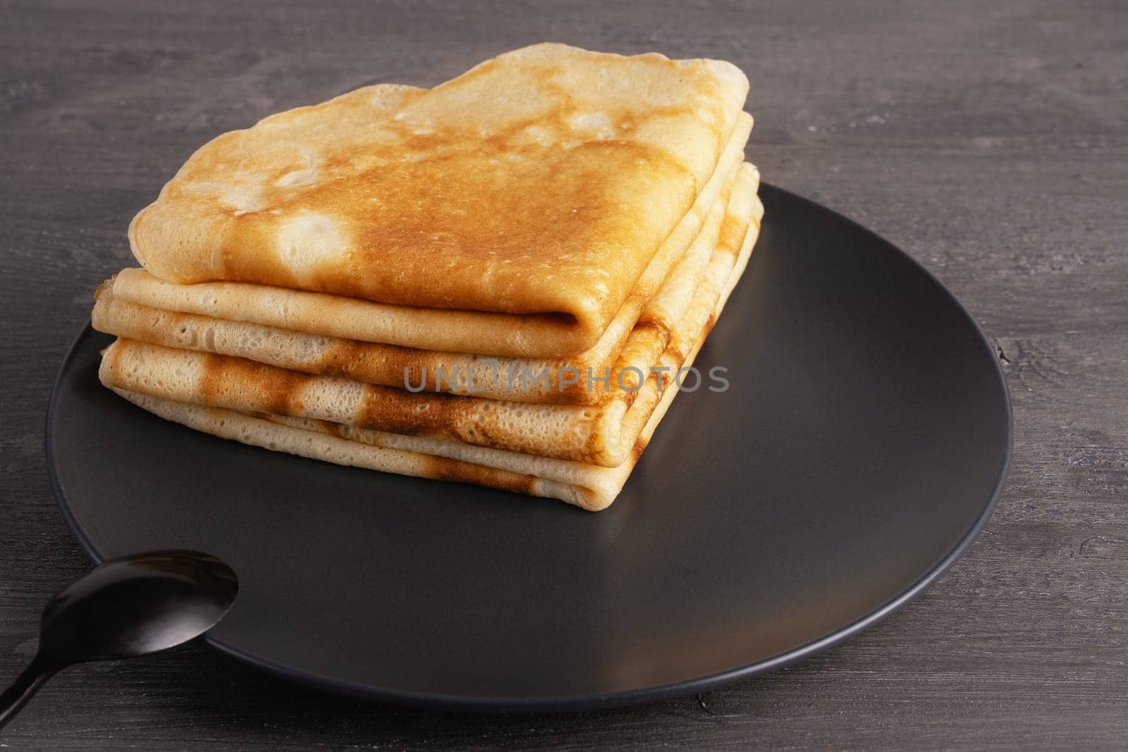 Thin pancakes on the grey background.