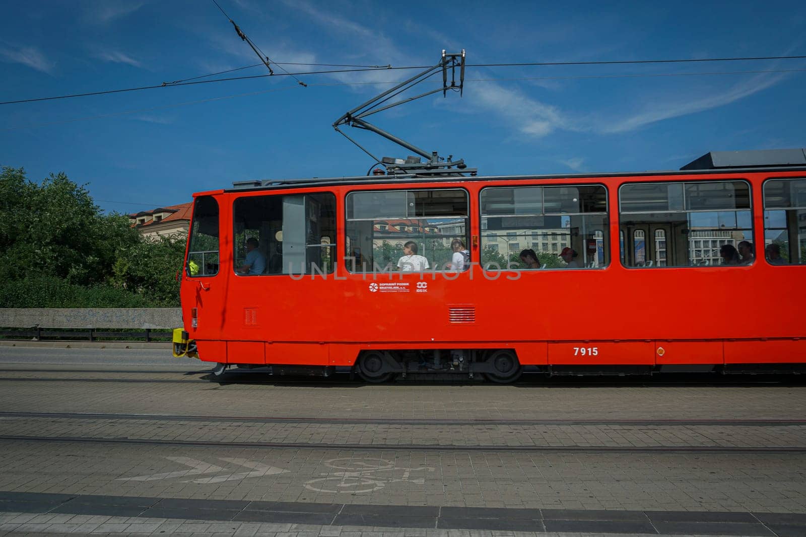 Bratislava, Slovakia - August 25, 2023: Tram passing on a cobblestone road by stan111