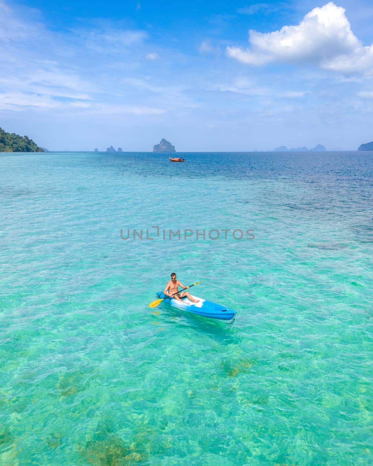 Young men in a kayak at the bleu turqouse colored ocean of Koh Kradan a tropical island with a coral reef in the ocean, Koh Kradan Trang Thailand