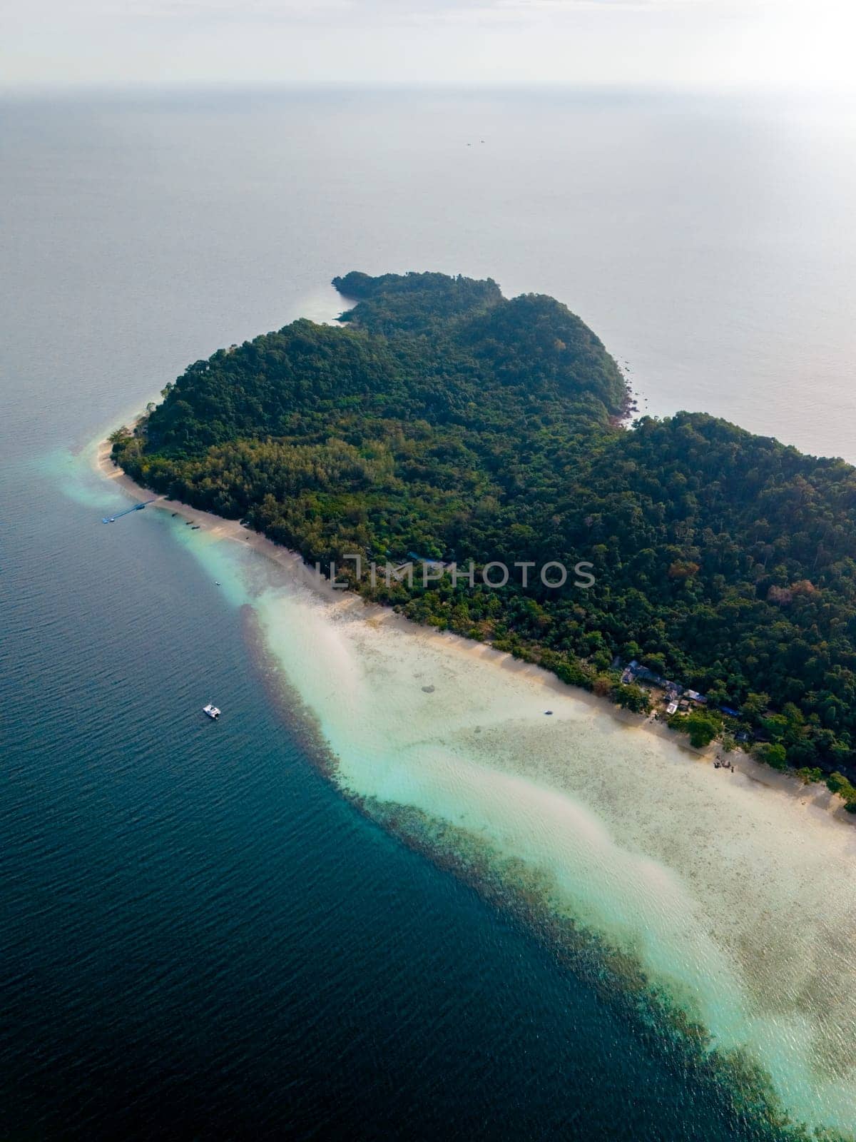 Drone top aerial view at Koh Kradan a tropical island with palm trees soft white sand, and a turqouse colored ocean in Koh Kradan Trang Thailand