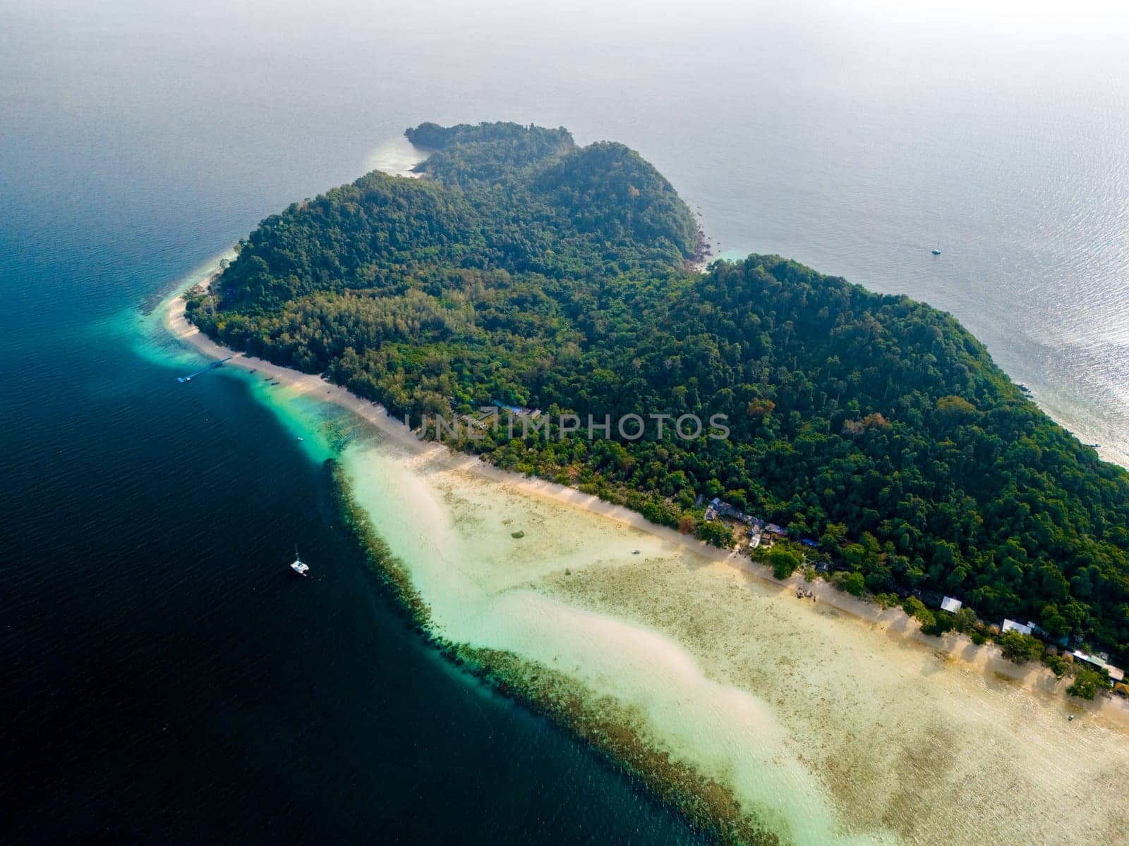 top aerial view at Koh Kradan a tropical island with palm trees soft white sand, and a turqouse colored ocean in Koh Kradan Trang Thailand