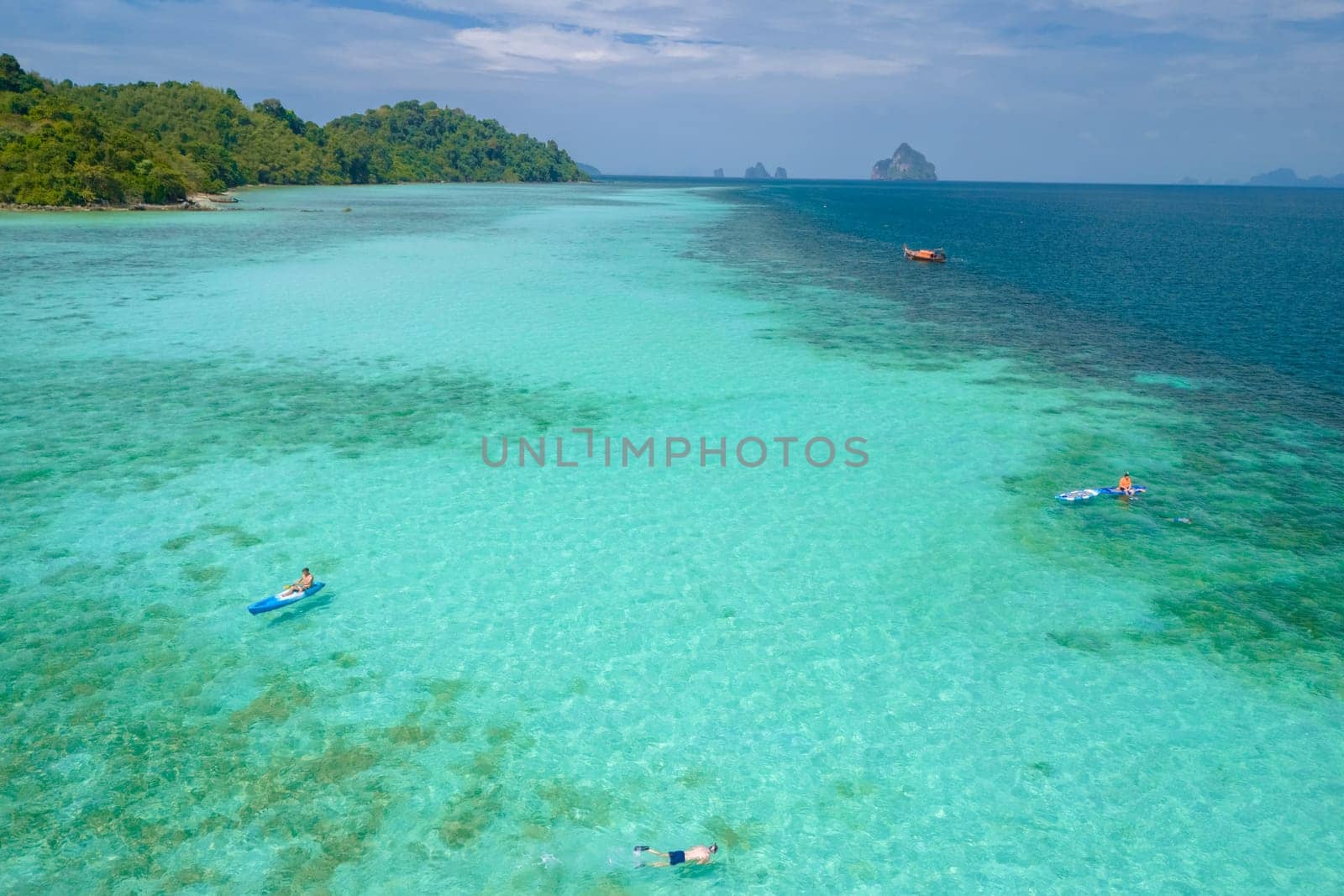 Young men in a kayak at the bleu turqouse colored ocean of Koh Kradan a tropical island with a coral reef in the ocean, Koh Kradan Trang Thailand