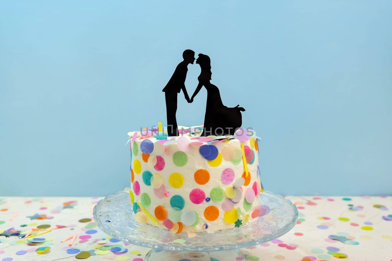 Bride and groom kissing cake toppers on decorated wedding cake. Newlywed figurines decoration on sweet wedding cake