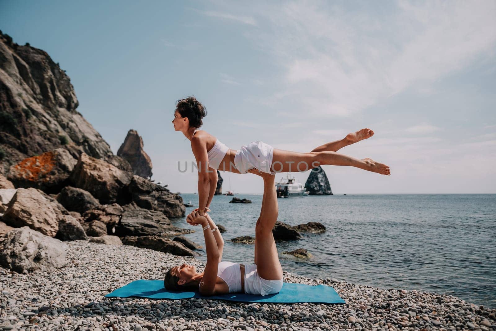 Woman sea yoga. Back view of free calm happy satisfied woman with long hair standing on top rock with yoga position against of sky by the sea. Healthy lifestyle outdoors in nature, fitness concept.