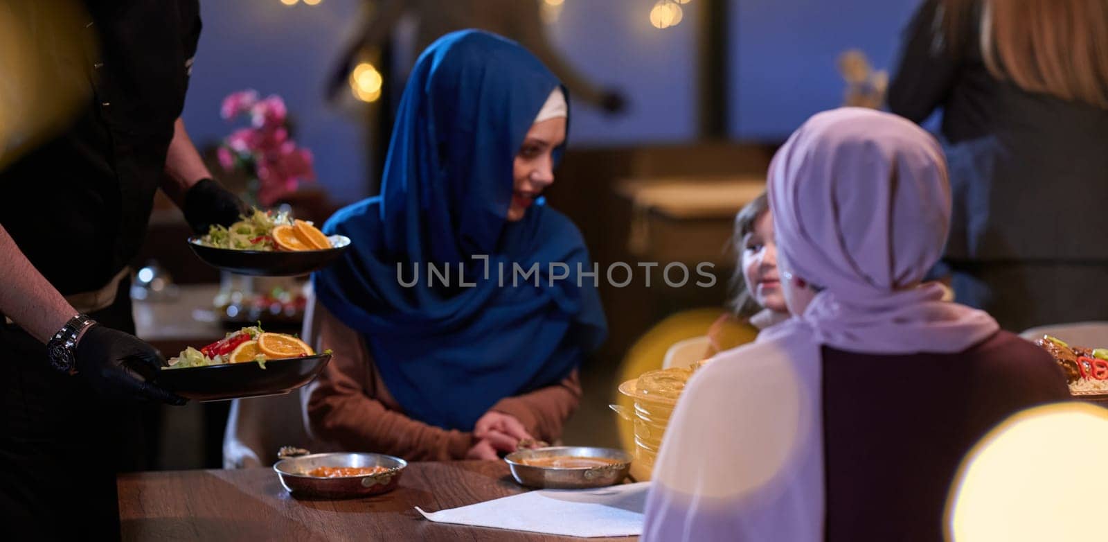 A modern and traditional European Islamic family comes together for iftar in a contemporary restaurant during the Ramadan fasting period, embodying cultural harmony and familial unity amidst a culinary celebration of diversity by dotshock