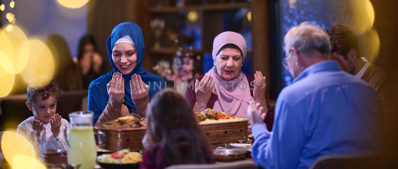 In a modern restaurant setting, a European Islamic family comes together for iftar during Ramadan, engaging in prayer before the meal, uniting tradition and contemporary practices in a celebration of faith and family.