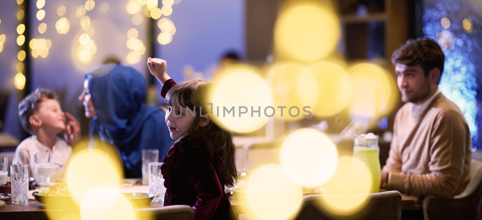 In a modern restaurant, an Islamic couple and their children joyfully await their iftar meal during the holy month of Ramadan, embodying familial harmony and cultural celebration amidst the contemporary dining ambiance by dotshock