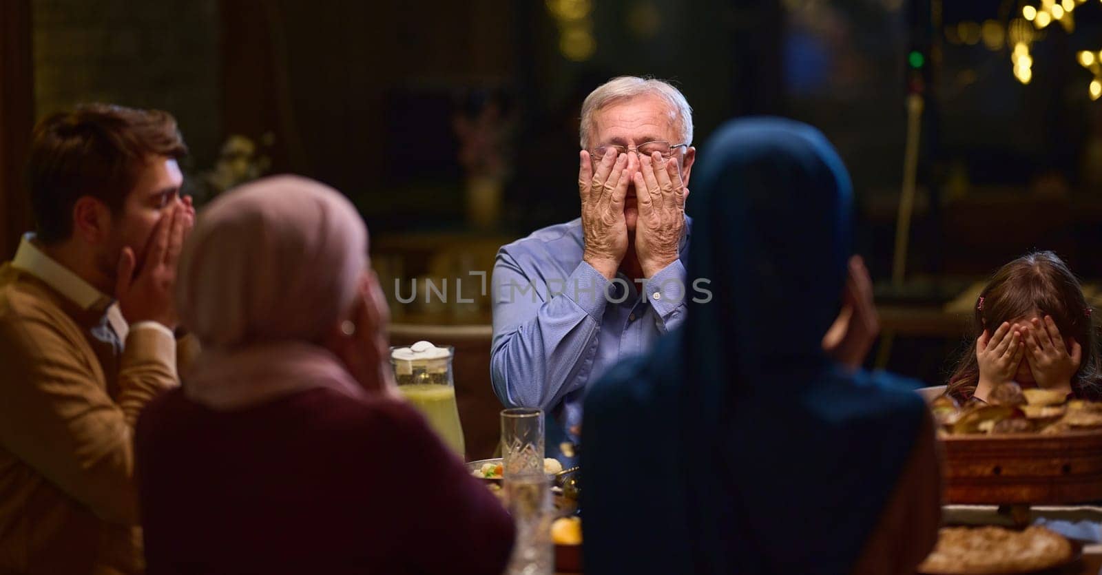 In a modern restaurant setting, a European Islamic family comes together for iftar during Ramadan, engaging in prayer before the meal, uniting tradition and contemporary practices in a celebration of faith and family by dotshock