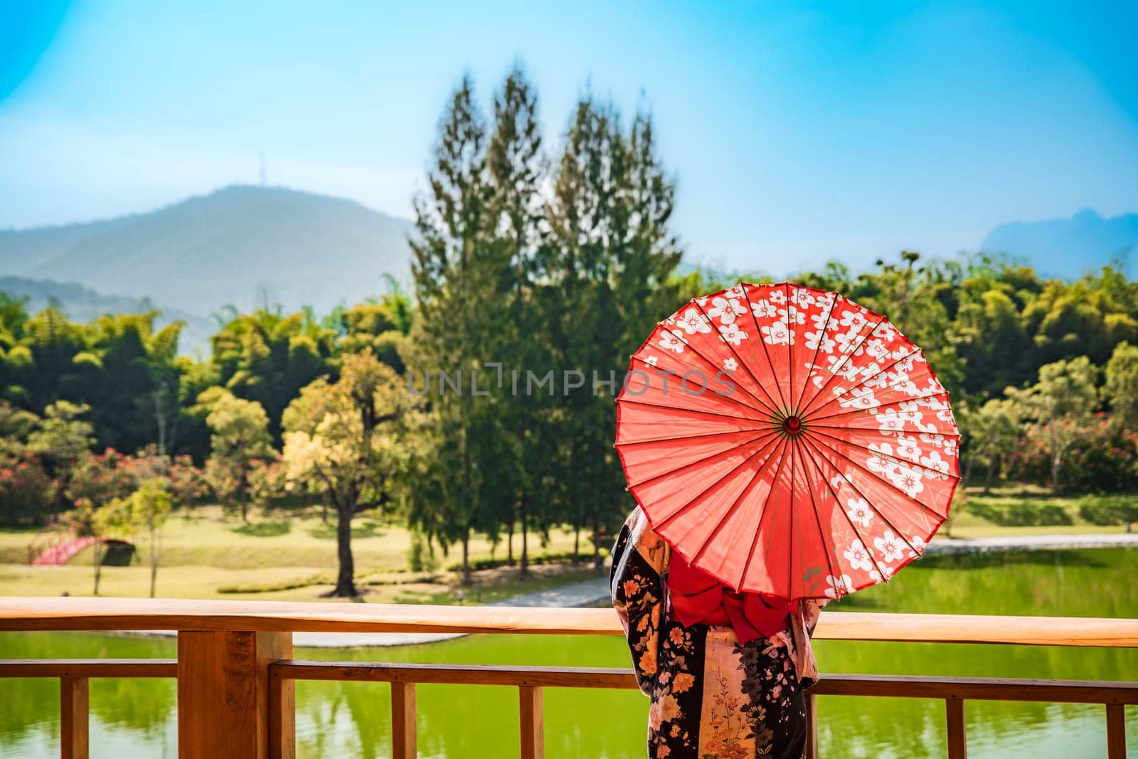 Asian girl in kimono and umbrella in Japanese theme park Hinoki Land in Chai Prakan District, Chiang Mai