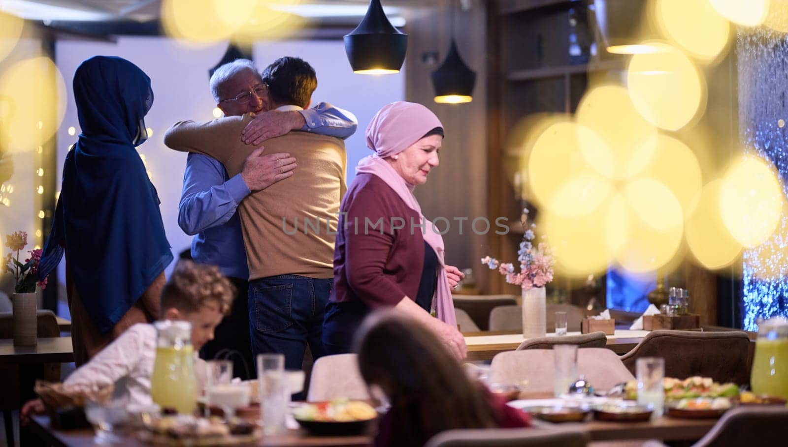 Grandparents arrive at their children's and grandchildren's gathering for iftar in a restaurant during the holy month of Ramadan, bearing gifts and sharing cherished moments of love, unity, and cultural exchange, as they eagerly await their meal together by dotshock