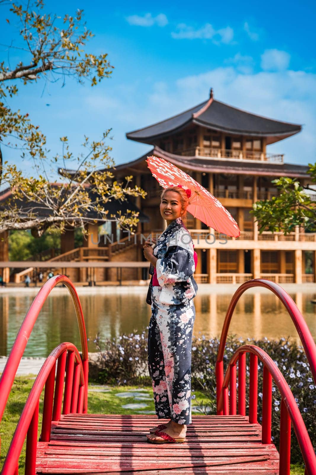 Asian girl in kimono and umbrella in Japanese theme park Hinoki Land in Chai Prakan District, Chiang Mai